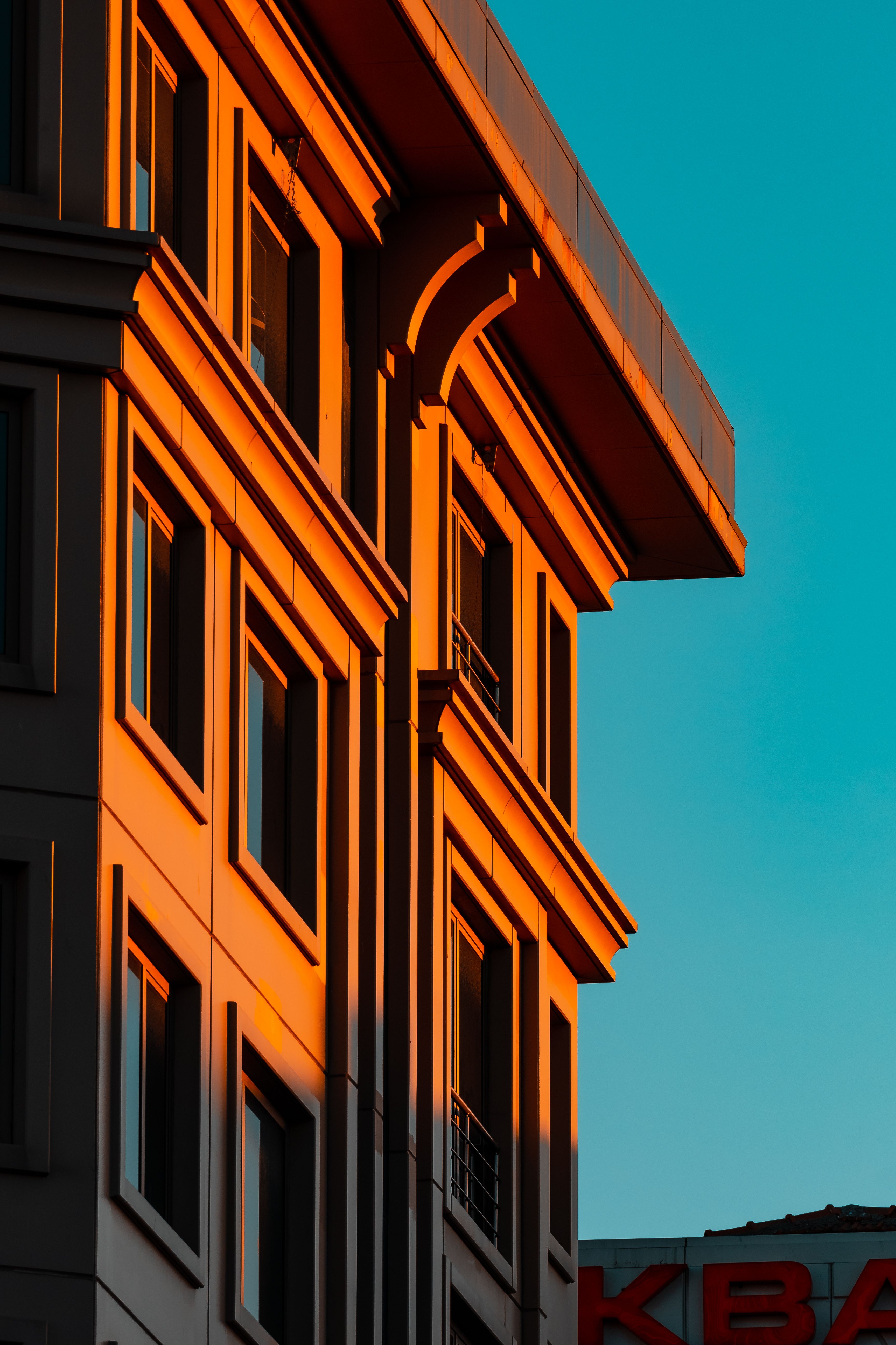 Sunlit building façade against a teal sky